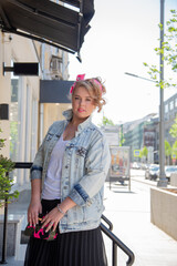 Portrait girl on vacation in the spring on a beautiful street outdoors surrounded by flowers.