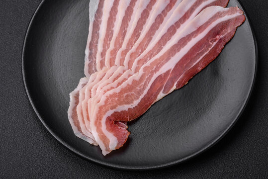 Delicious fresh pancetta with salt and spices cut into thin slices
