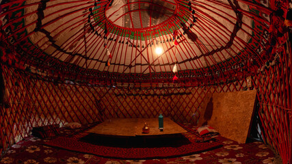 A bulb-lit interior of a yurt at a campsite in the Kyrgyz village of Ozgrush.