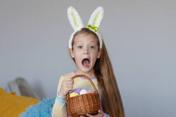 Happy easter! Portrait of funny happy laughing child girl with easter eggs and bunny ears on white background. funny wow face.
