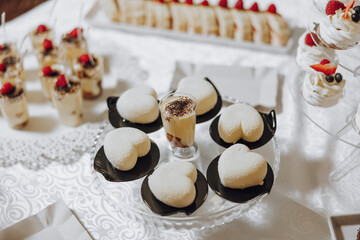 Candy bar. Table with sweets, candies, dessert. cakes and berries in the candy bar. Candy bar with delicious mini cakes, selective focus