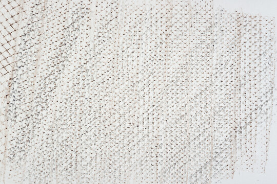 frottage technique featuring a grid or net pattern on tracing paper and photographed on a white backlit surface