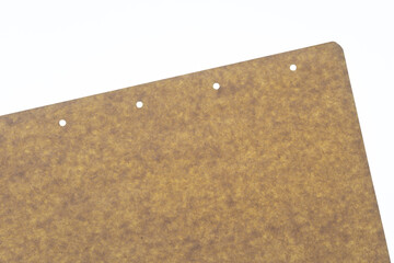 brown paper sheet with small holes on a white backlit surface