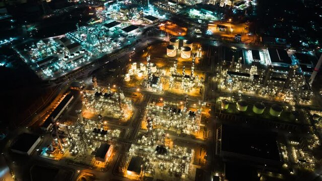 Hyperlapse time lapse of petroleum oil refinery in industrial estate at night, drone aerial view. Fuel and power generation, petrochemical factory industry, or environmental air pollution concept