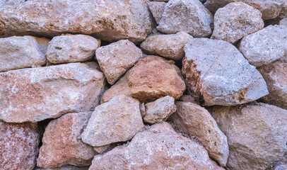 Texture of a stone wall. Old castle stone wall texture background. Brown, sienna large stones. Part of a stone wall, for background or texture.