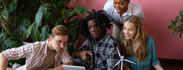 Diverse group of international students working on the urban project of modern city with renewable energy source, green areas. Concept of ecology, environment, waste recycling, technology. Banner