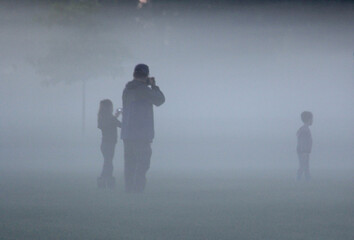 Family playing in the early morning fog