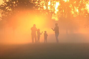 Family playing in the early morning fog