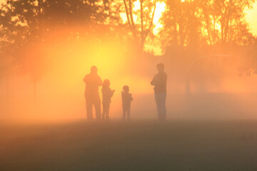 Family playing in the early morning fog