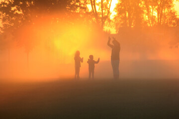 Naklejka na ściany i meble Family playing in the early morning fog