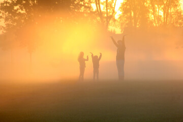Family playing in the early morning fog
