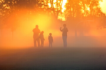 Family playing in the early morning fog