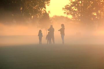 Family playing in the early morning fog