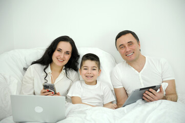 Fototapeta na wymiar family and son watching and play tablet on bed. High quality photo