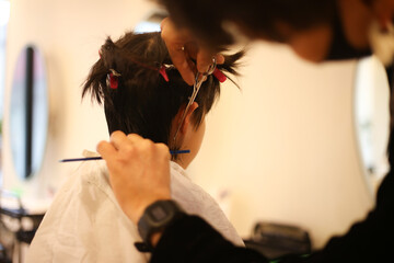男の子の髪を切る男性美容師
