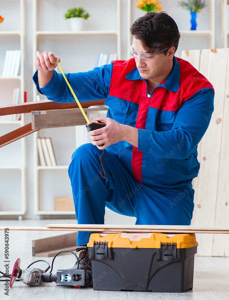 Wall mural Young carpenter working with wooden planks