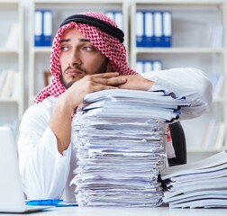 Arab businessman working in the office doing paperwork with a pi