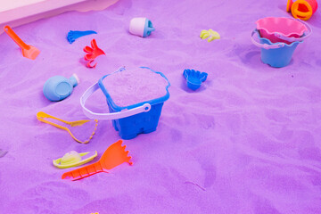Plastic children's toys for playing on the purple sand.