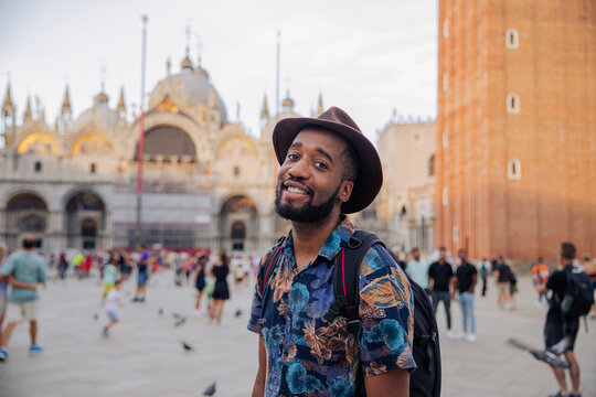 A smiling African american tourist in Venice at Piazza San Marco during a summer day