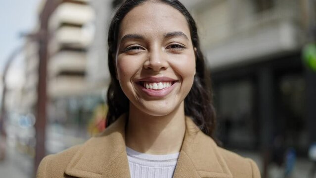 Young beautiful hispanic woman smiling confident at street