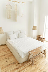a beautiful bright room with a large bed and a white bed. eco style interior. wooden floor. beautiful decor