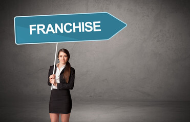 Young business person in casual holding road sign