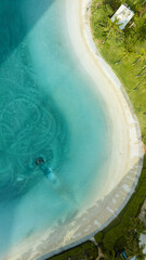 Fototapeta premium Beautiful ocean lagoon overview with white sand and palm trees in Honolulu Hawaii. Aerial drone top-down view.
