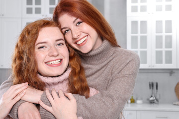 Portrait of beautiful young redhead sisters in kitchen