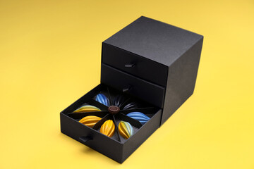 Box of tasty chocolate candies on yellow background
