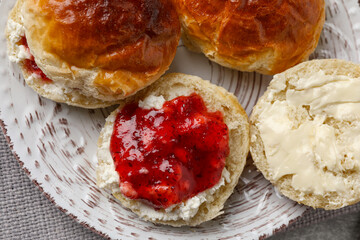 Freshly baked soda water scones with cranberry jam and butter on table, top view