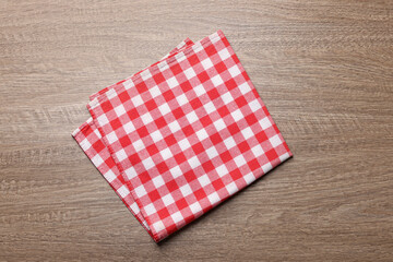 Checkered tablecloth on wooden table, top view