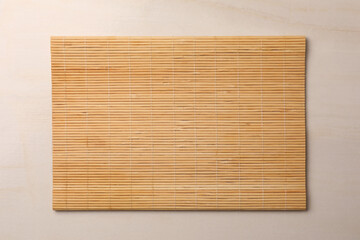 Bamboo mat on beige table, top view. Space for text