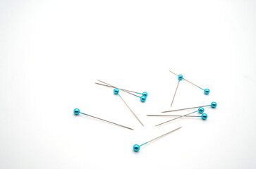 A silver handle pin with a blue round head on a white background. For tailors used in the past to the present
