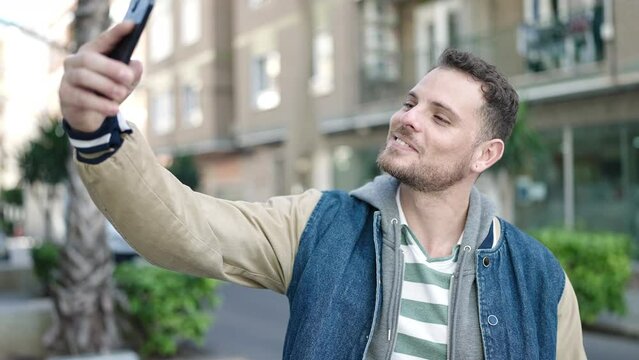 Young caucasian man smiling confident taking selfie picture at street