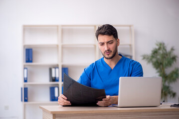 Young doctor radiologist sitting at the hospital
