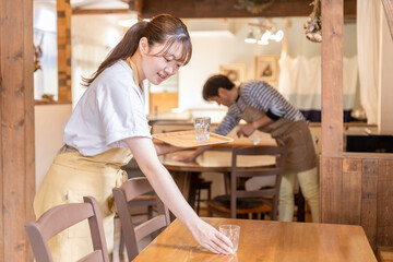 カフェ・飲食店で後片付けをする従業員・スタッフ・バイトの若い女性

