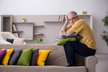 Obraz premium Old man with many pillows at home