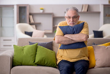 Old man with many pillows at home