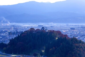 展望台から見下ろす紅葉に囲まれた朝のお城の情景＠福井