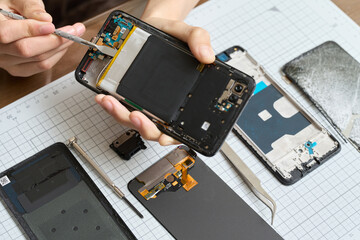 スマートフォンの分解をする手元 © mapo