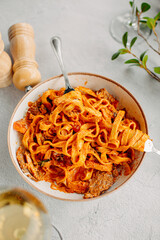 Pasta bavette with fried shrimps, bechamel sauce. Woman hands in frame, girl eats pasta, holds fork in hands, top view, italian cuisine.