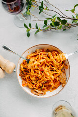 Pasta bavette with fried shrimps, bechamel sauce. Woman hands in frame, girl eats pasta, holds fork in hands, top view, italian cuisine.
