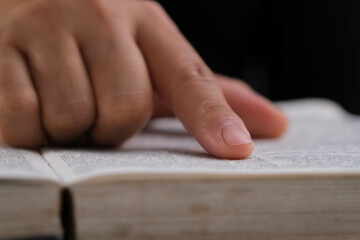 Close up of a woman reading a book and looking through the pages. Love of reading and education