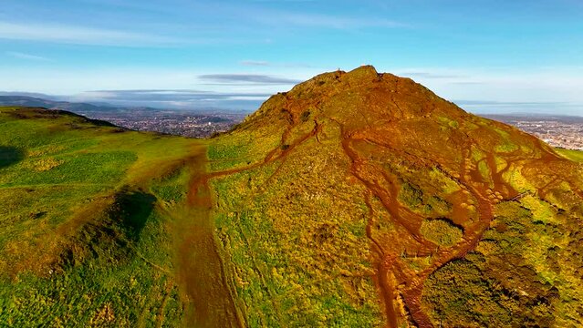Aerial footage of Arthurs seat with the Old city of Edinburgh on the background