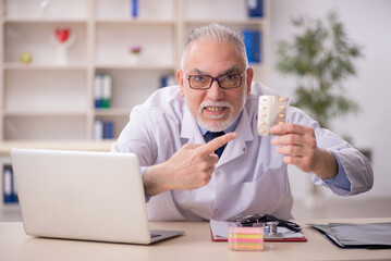 Old male doctor working in the clinic