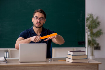 Young male teacher in telestudying concept
