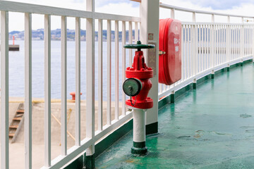 船の甲板の赤く塗装された消火栓と消火ホース箱