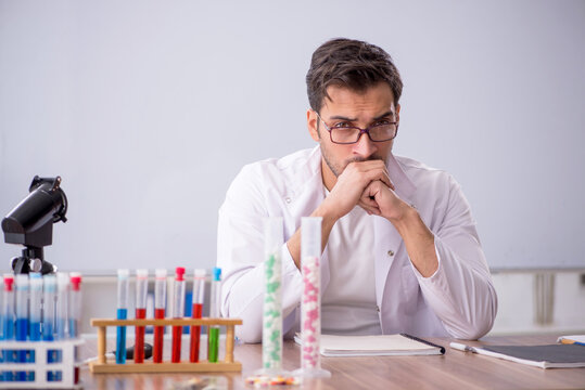 Young male chemist in front of white board