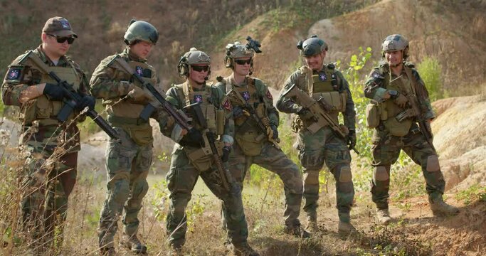 young people in camouflage have rest, standing in row waiting for commander, preparing for war slow motion, free time spare time