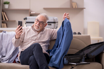 Old man preparing for trip at home